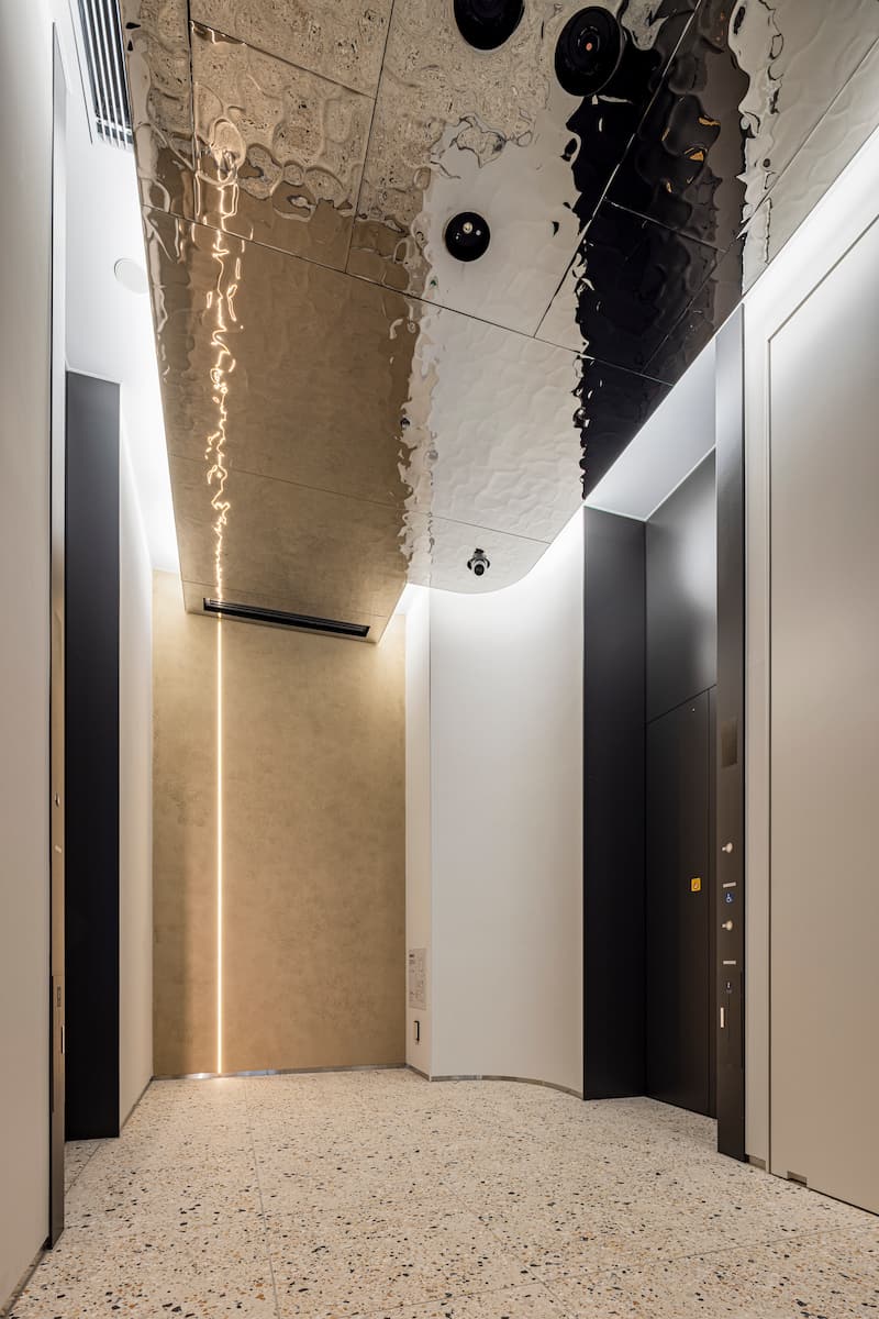 エレベーターホールの天井には水面を表現した金属パネル