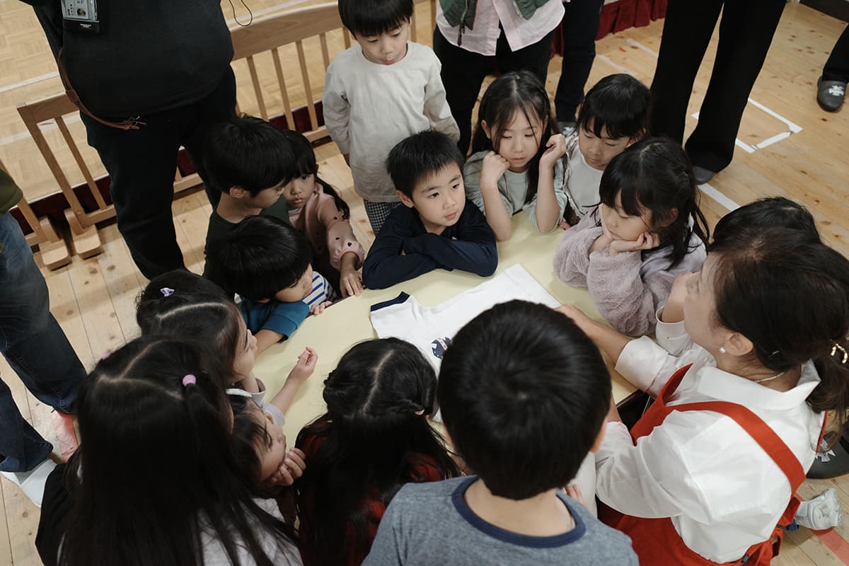 粂井氏が運営するお手伝い塾・粂井塾が全国で教えている「服の3秒たたみ」など、お手伝いデビューにもおすすめな簡単家事術を伝授してもらう園児たち。